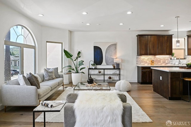 living area featuring recessed lighting, light wood-style floors, and baseboards