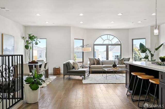 living area featuring recessed lighting, visible vents, and hardwood / wood-style flooring