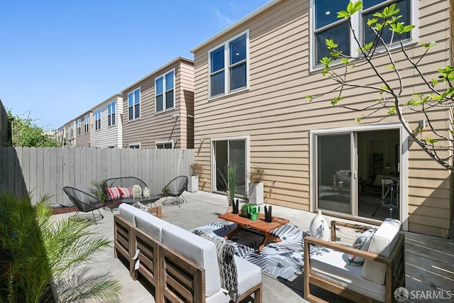back of property with fence, a patio area, and an outdoor hangout area