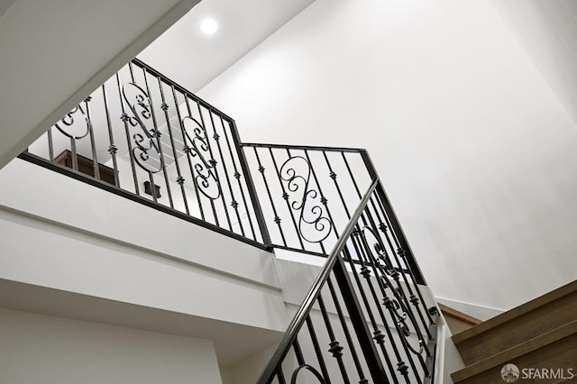 stairway featuring a towering ceiling and recessed lighting
