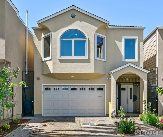 view of front of house featuring a garage, decorative driveway, and stucco siding