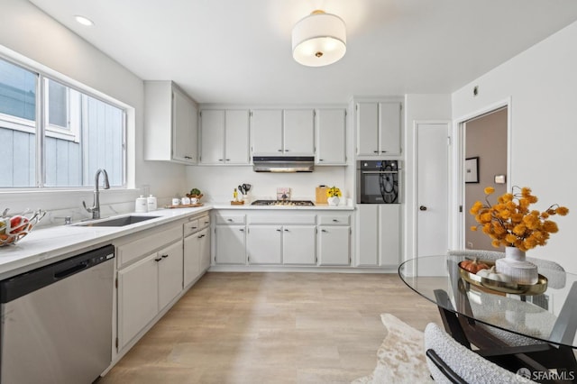 316 Gold Mine Dr, San Francisco, CA 94131 - kitchen featuring a sink, appliances with stainless steel finishes, light countertops, under cabinet range hood, and light wood finished floors