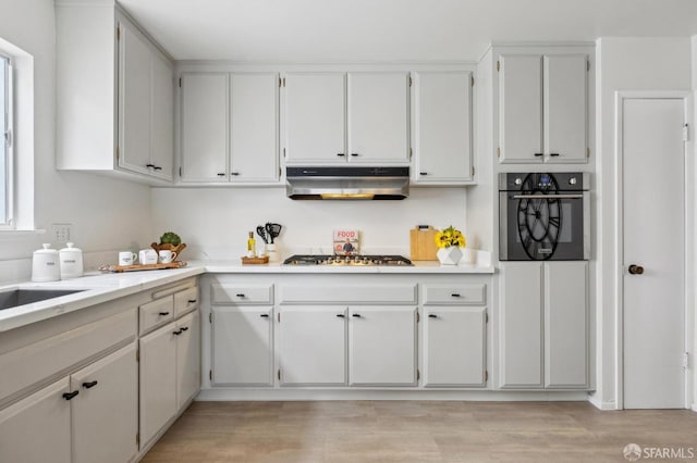 316 Gold Mine Dr, San Francisco, CA 94131 - kitchen featuring white cabinets, appliances with stainless steel finishes, light countertops, under cabinet range hood, and light wood finished floors