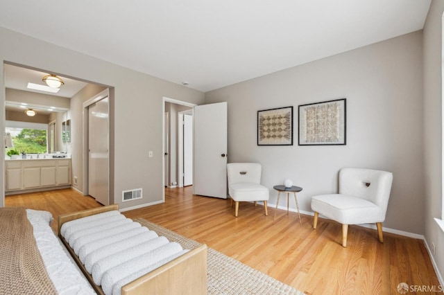 316 Gold Mine Dr, San Francisco, CA 94131 - bedroom with baseboards, visible vents, light wood-style floors, and connected bathroom