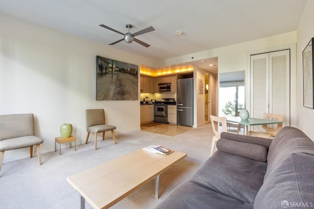 carpeted living room with ceiling fan