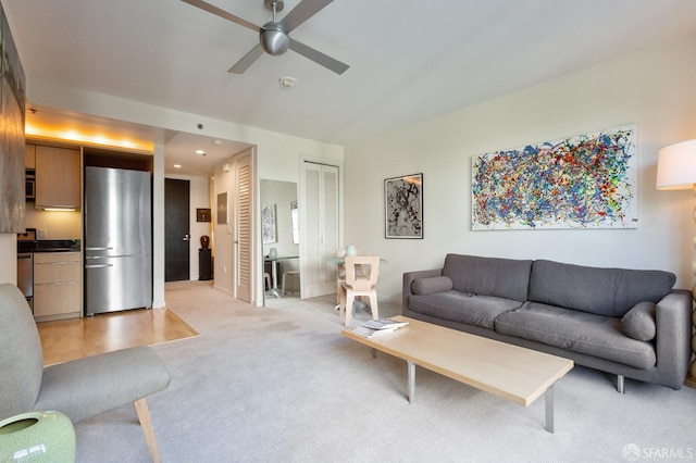 carpeted living room with ceiling fan