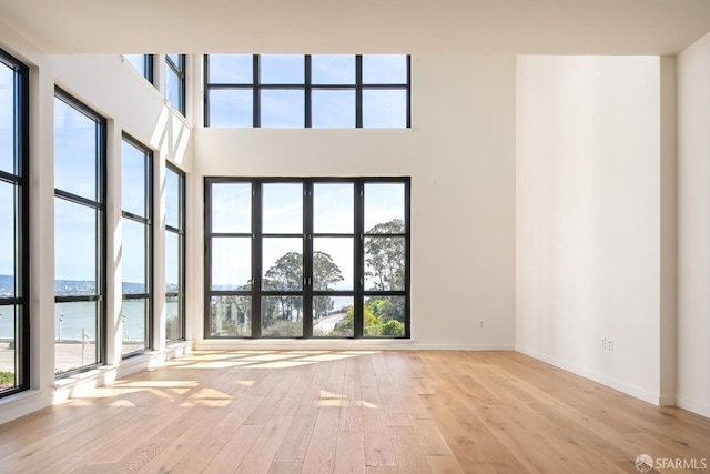 interior space with a water view and light hardwood / wood-style flooring