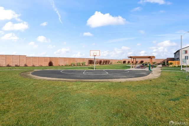 view of sport court with a lawn