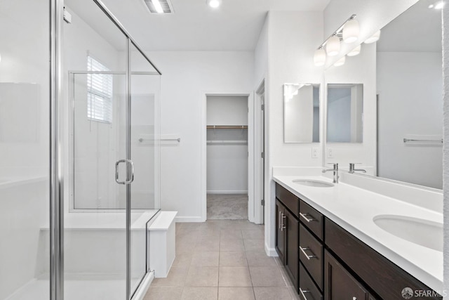 bathroom featuring tile patterned floors, vanity, and a shower with door