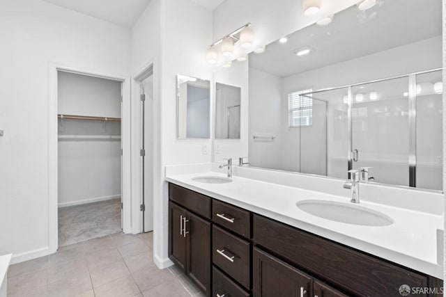 bathroom featuring tile patterned flooring, vanity, and a shower with door