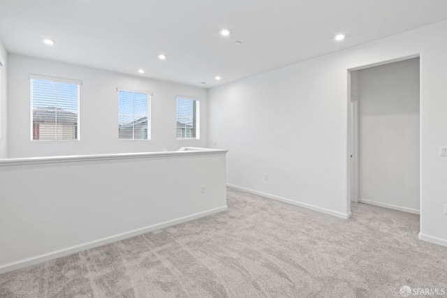 empty room with light colored carpet and a healthy amount of sunlight