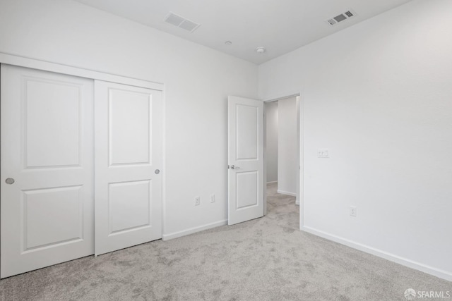 unfurnished bedroom with a closet and light colored carpet