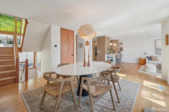 dining area with light wood-style floors, stairs, and recessed lighting