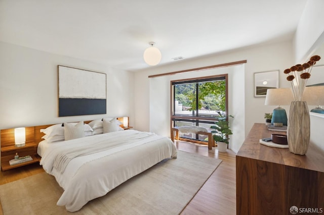 bedroom with light wood finished floors and visible vents