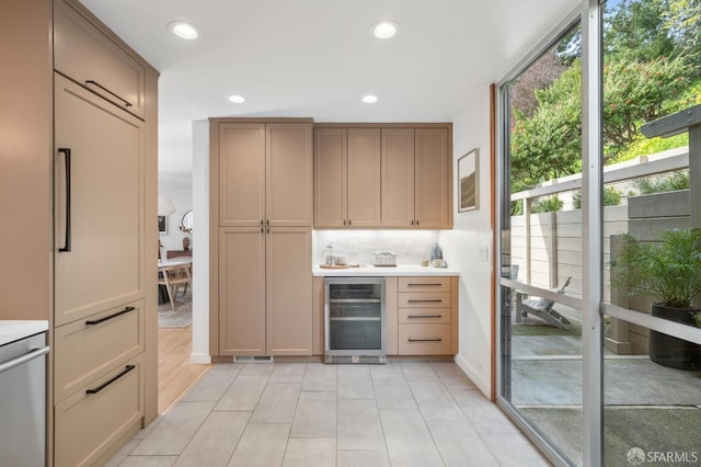 interior space featuring light tile patterned floors, decorative backsplash, wine cooler, light countertops, and recessed lighting