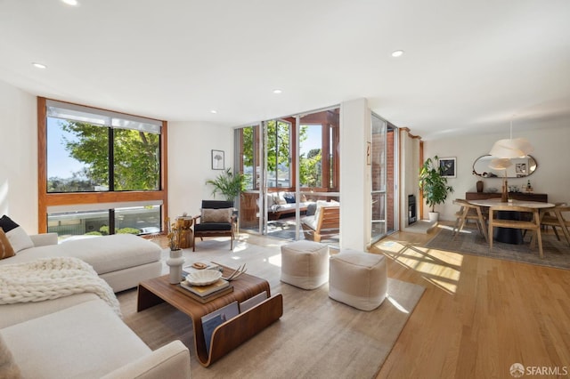 living area featuring expansive windows, wood finished floors, and recessed lighting