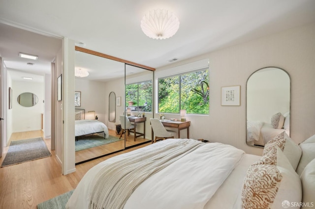 bedroom featuring a closet, visible vents, and light wood finished floors