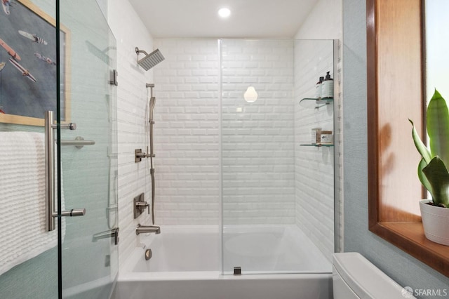 bathroom with combined bath / shower with glass door and toilet