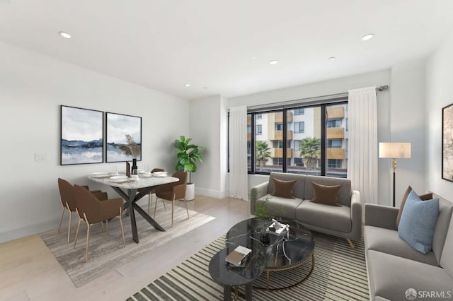 living area with recessed lighting, baseboards, and light wood-style flooring