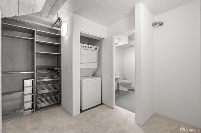 interior space featuring stacked washer and clothes dryer and toilet