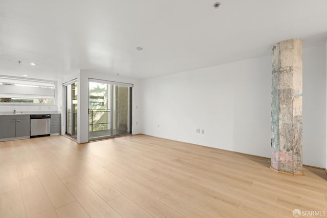 unfurnished living room featuring light hardwood / wood-style floors and sink