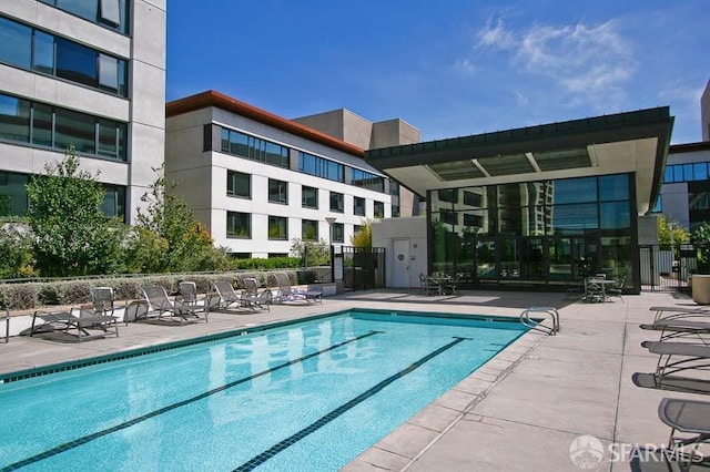 pool with fence and a patio