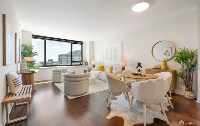 living room featuring baseboards, dark wood-style flooring, and a city view