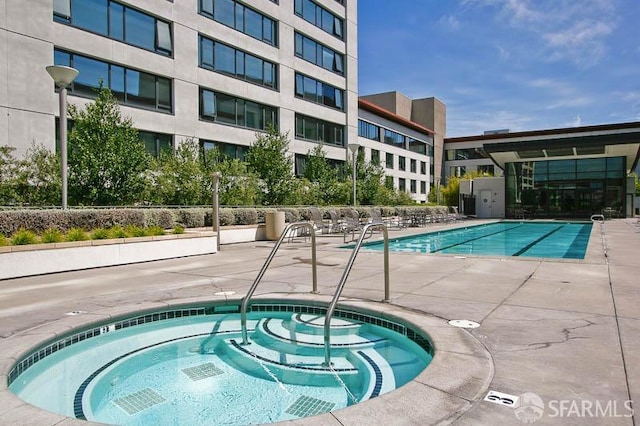 view of pool with a community hot tub and a patio