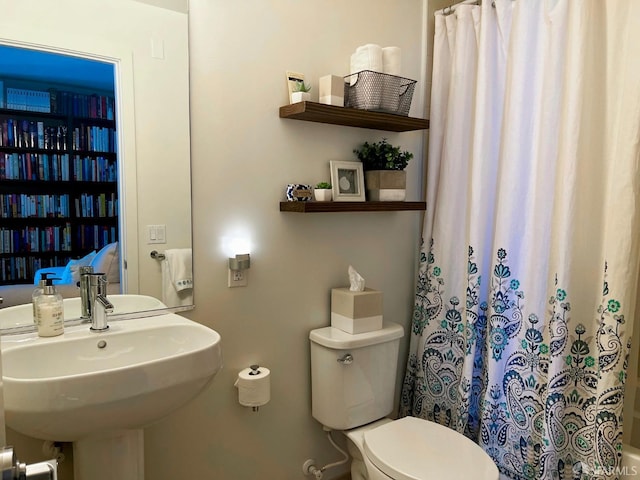 full bath with curtained shower, a sink, and toilet