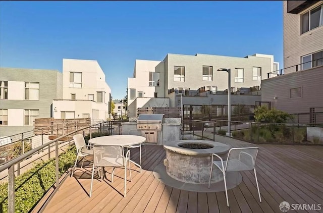 wooden terrace featuring a fire pit and grilling area