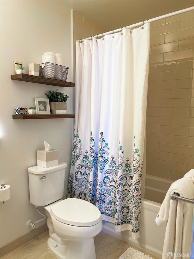 bathroom with shower / bath combo, baseboards, and toilet