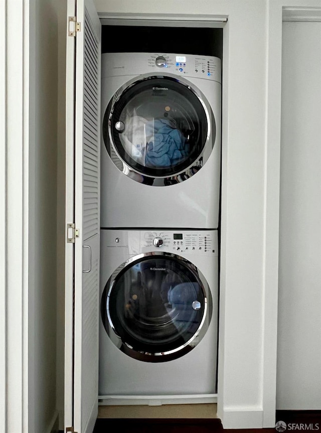 clothes washing area featuring laundry area and stacked washer / dryer