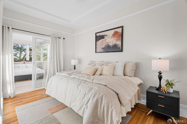 bedroom featuring access to exterior and hardwood / wood-style floors