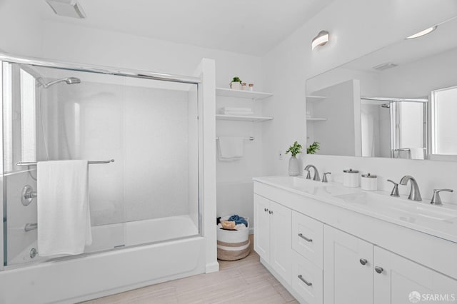 bathroom featuring vanity and combined bath / shower with glass door