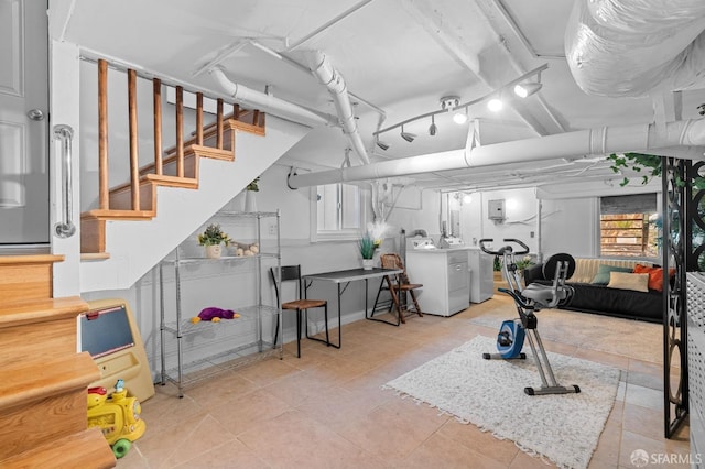 exercise area with washing machine and dryer and light tile patterned floors