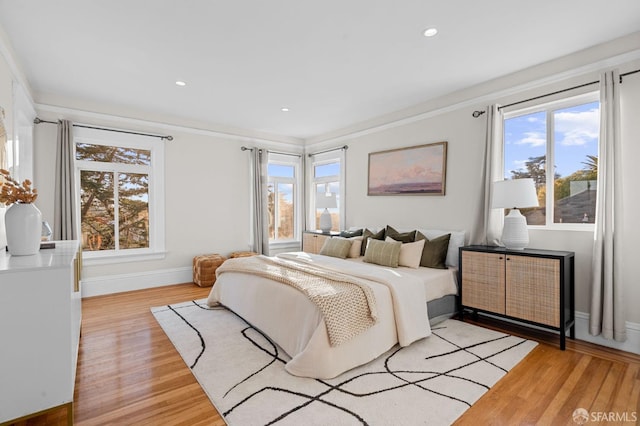 bedroom featuring crown molding and light hardwood / wood-style flooring