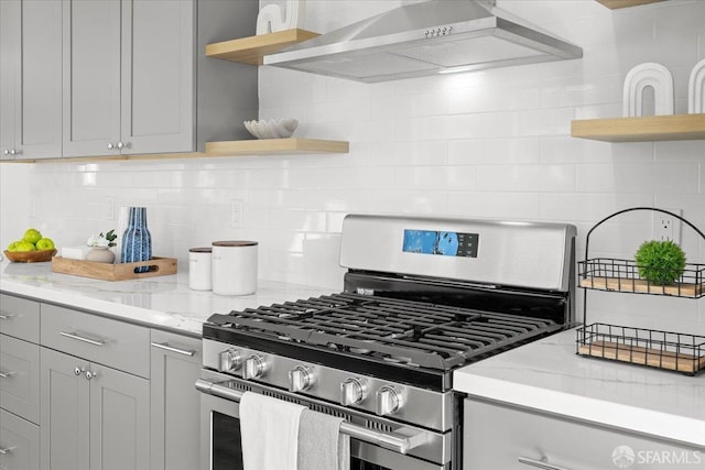 kitchen featuring open shelves, wall chimney range hood, backsplash, and gas range