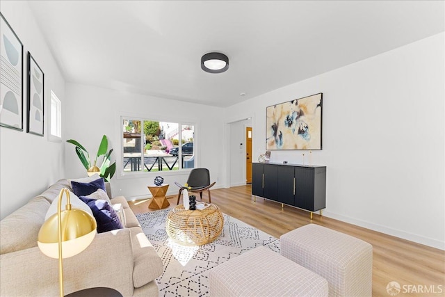 living area with light wood-style flooring and baseboards