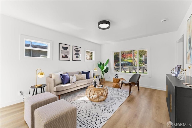 living area with light wood-type flooring and baseboards