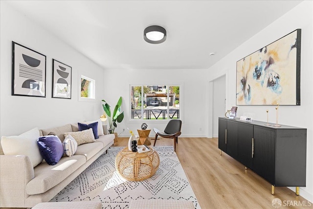 living area featuring light wood-style flooring and baseboards