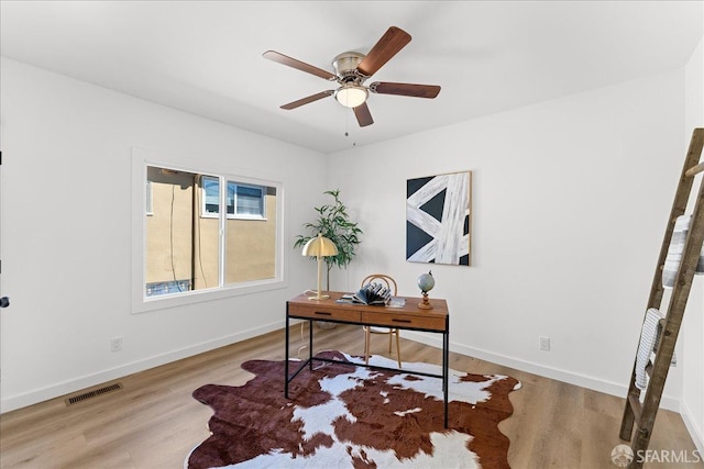 home office featuring a ceiling fan, baseboards, visible vents, and wood finished floors