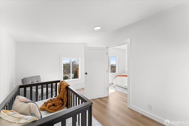 bedroom featuring light wood finished floors and baseboards