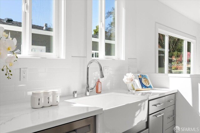 interior space featuring tasteful backsplash, a sink, and gray cabinetry