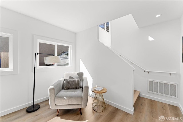 sitting room featuring visible vents, baseboards, and wood finished floors