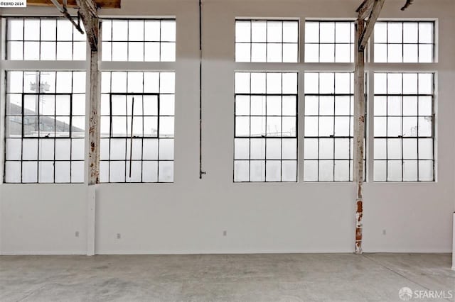 empty room with plenty of natural light and concrete flooring