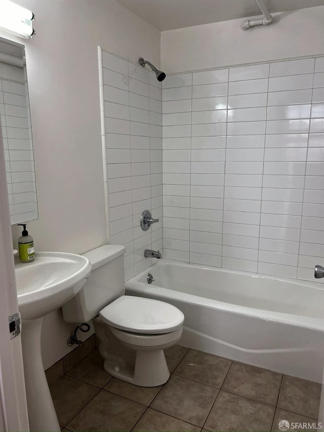 bathroom with tile patterned flooring, tiled shower / bath combo, and toilet