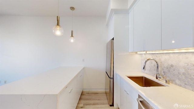 1338 Stevenson St, San Francisco, CA 1906 - kitchen with freestanding refrigerator, backsplash, white cabinetry, a peninsula, and modern cabinets