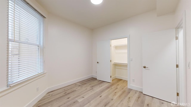 1338 Stevenson St, San Francisco, CA 1906 - unfurnished bedroom with light wood-style flooring, a walk in closet, and a closet