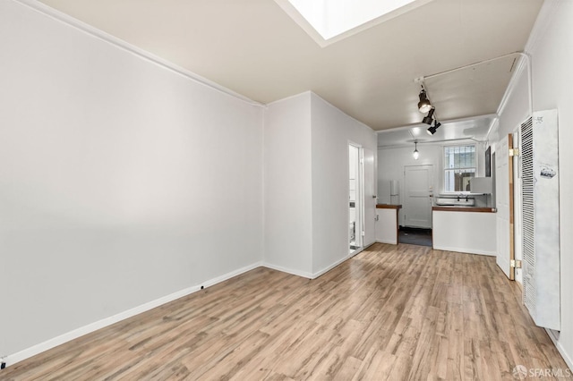 737 Minna St, San Francisco, CA 94103 - unfurnished living room with baseboards, a heating unit, a skylight, and wood finished floors