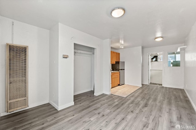 737 Minna St, San Francisco, CA 94103 - unfurnished living room with baseboards, a heating unit, and light wood-style flooring